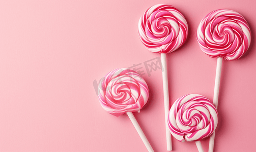 可口食品摄影照片_粉红色背景上甜美可口的粉红色棒棒糖最小的平面布局带有复制空间