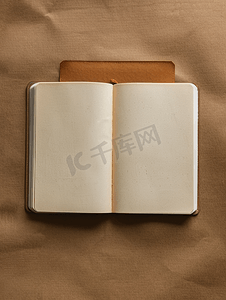 打开的空笔记本的顶视图封面由棕色背景的再生纸制成