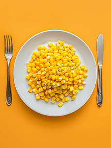 白盘和钢叉上的甜玉米顶视图