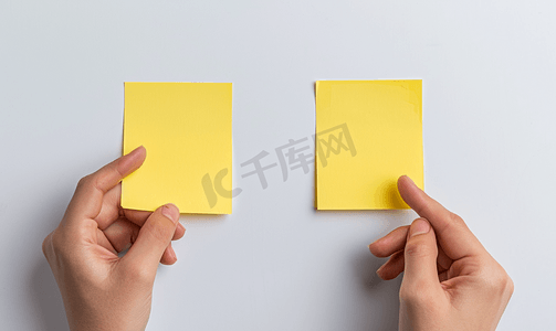 图钉便签条摄影照片_两张空白的黄色便签用手指放在白板上