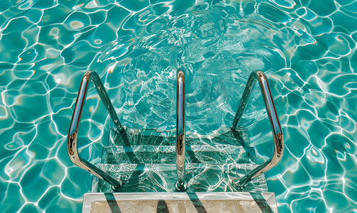 清澈的游泳池梯子的金属栏杆