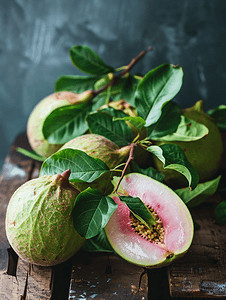 餐桌上的水果摄影照片_木制背景上新鲜绿叶的美味番石榴的特写