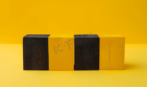 创意几何形状摄影照片_空的四块黄色木块矩形形状中间有一块黑色木块
