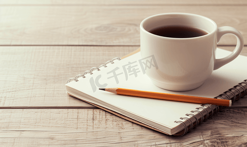 木桌背景上带铅笔和咖啡杯的空白笔记本