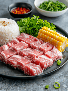 猪肉荠菜摄影照片_新鲜猪肉生切片配上米饭和玉米放在盘子上准备做饭