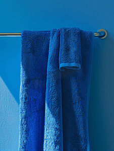 浴室浴巾摄影照片_一条蓝色毛巾挂在衣架杆上