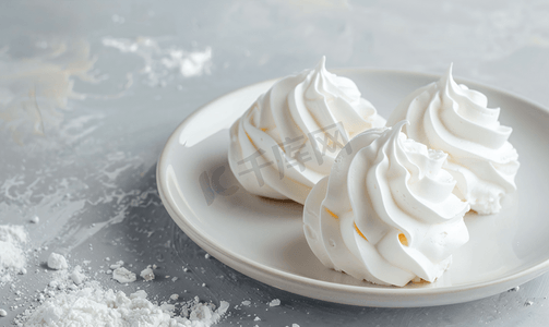 白盘子上的两个雪白蛋白饼漂亮的白色蛋糕混凝土背景