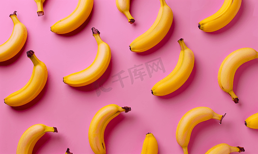 粉红色背景上鲜黄香蕉的彩色水果图案从顶部看