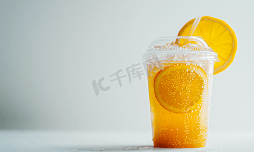 红色果汁摄影照片_白色背景下塑料杯中橙子的冰沙