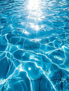 透明水波纹摄影照片_蓝色泳池水面与太阳反射的水背景