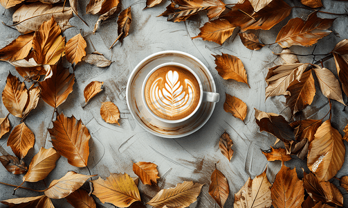 假期表摄影照片_干燥秋叶环框中的咖啡拿铁杯