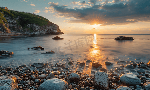 在大海上晒长曝光日落在岩石海滩上晒太阳