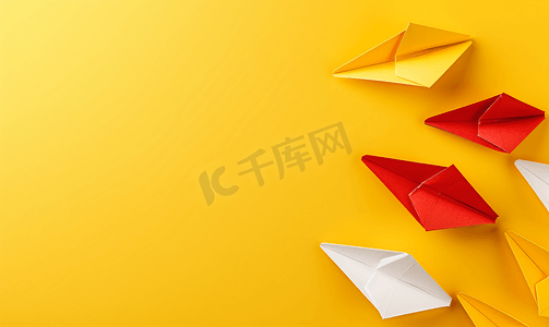 折纸风海报摄影照片_黄色背景中的红白纸船领导概念复制空间