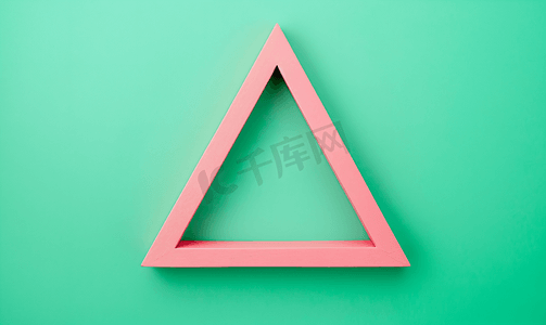 绿色几何背景摄影照片_绿色背景框架中的粉色三角形顶视图复制空间