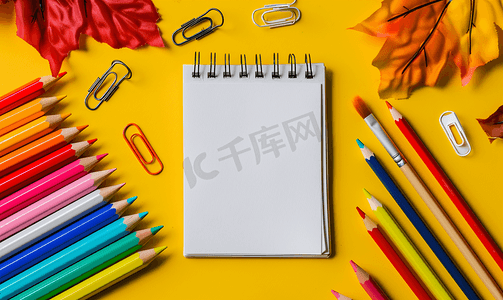 黄色背景上的水彩画彩色铅笔纸夹和记事本