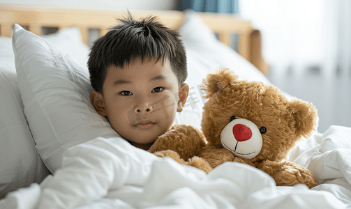 亚洲男孩患流感棕熊躺在病床上治