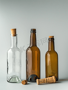 几桌子摄影照片_空酒瓶附近翻倒的酒瓶和软木塞