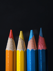 彩色铅笔摄影照片_黑色背景上一排排带橡皮擦的彩色铅笔