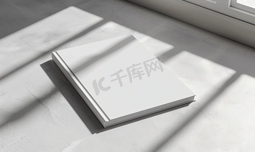 中性摄影照片_中性灰色混凝土背景上带有柔和阴影的空白笔记本模型