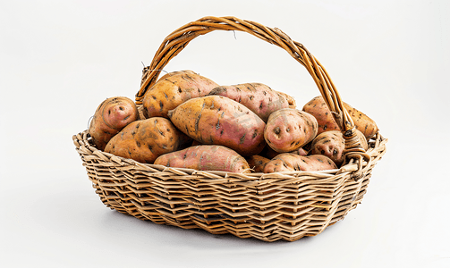 植物马铃薯摄影照片_孤立的白色背景上柳条篮中的红薯