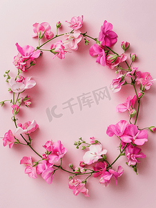 粉色夏天背景摄影照片_用粉色紫罗兰花在柔和的背景上制成的圆圈