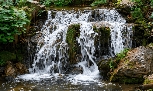 瀑布水流摄影照片_奥地利森林里有乳白色水流的小瀑布