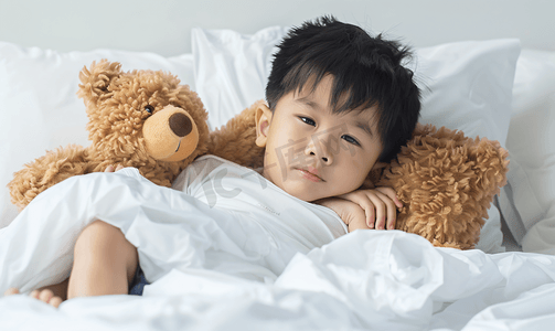 亚洲男孩患流感棕熊躺在病床上治