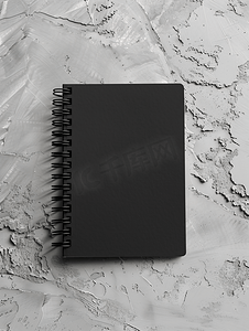 灰色商务模板摄影照片_中性灰色混凝土背景上带有柔和阴影的空黑色笔记本模型