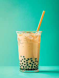 夏季果汁系列摄影照片_蓝色背景玻璃中的泡沫波巴茶加牛奶和木薯珍珠