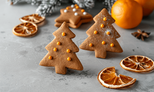 圣诞树摄影照片_灰色混凝土背景上姜饼圣诞树装饰干柑橘水果