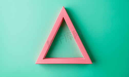 创意几何蓝色摄影照片_绿色背景框架中的粉色三角形顶视图复制空间