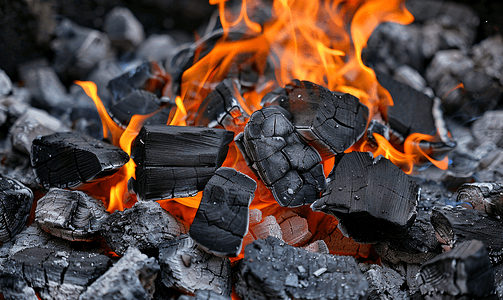 红色火焰燃烧摄影照片_燃烧的木头燃烧的煤上的火焰