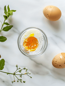 破裂鸡蛋摄影照片_玻璃蛋杯中裂开的煮鸡蛋的顶视图