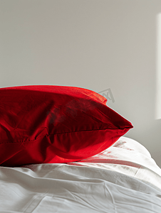 白色床摄影照片_白色背景下的红色枕头