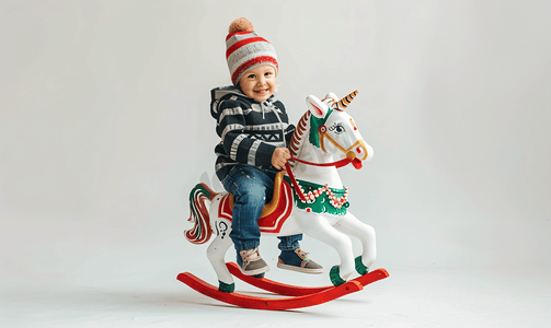 小装饰小玩意摄影照片_一个快乐的孩子骑着摇马的照片