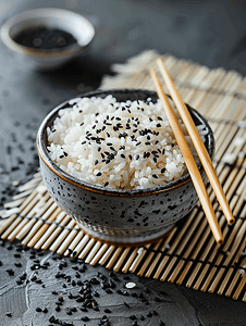 用筷子将米饭和黑芝麻放在竹席上蒸熟