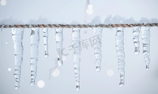 挂水摄影照片_冬天用绳子上的冰柱做成的花环