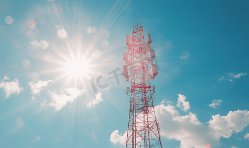 明亮的蓝天和太阳耀斑背景上带有发射天线的电信塔