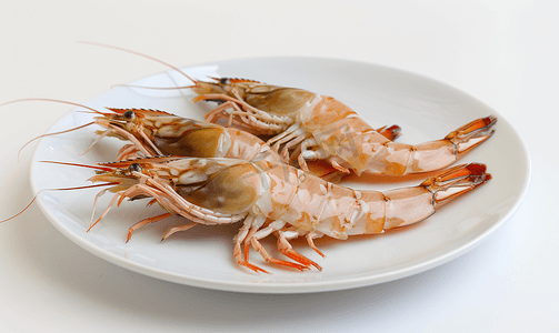盘子上的虎虾和白色背景