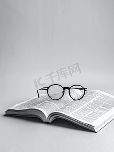 书卷标题摄影照片_戴着白色背景眼镜的商业报纸模型