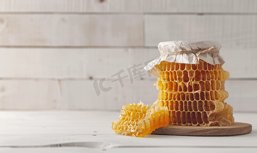 北斗勺子摄影照片_白色木质背景上带罐子和勺子的蜂巢