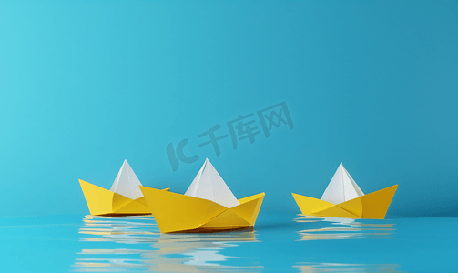 引领蓝色摄影照片_一艘白纸船引领着蓝色背景的三艘黄船
