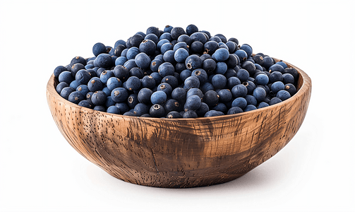 白色背景中分离的木碗中的靛蓝或靛蓝种子