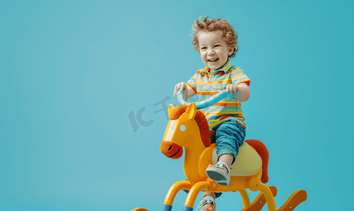 小装饰小玩意摄影照片_一个快乐的孩子骑着摇马的照片