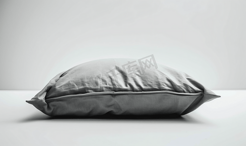 白色床摄影照片_白色背景下的灰色枕头