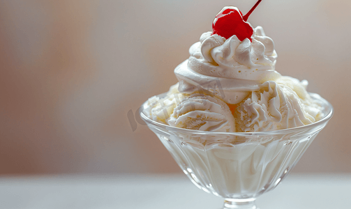 白色冰淇淋球摄影照片_玻璃碗里的冰淇淋上面有生奶油和红樱桃