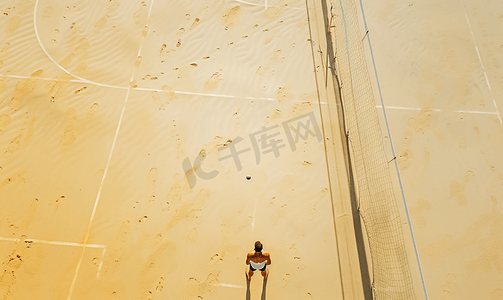 气排球幕布摄影照片_无人机俯视沙滩排球场上无法辨认的赤裸上身的男子的画面