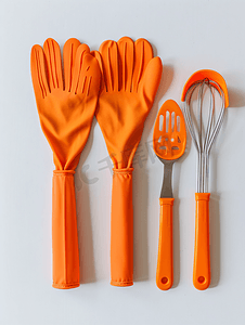 白色背景中带厨房用具的橙色耐热烹饪手套