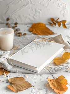 白色空白书白桌上放着秋叶、玻璃和蜡烛模型设计
