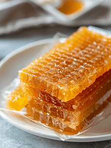 甜食夹头放在白色盘子上的包装中用面团制成的蜂蜜小吃特写